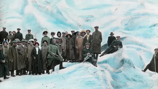 Bild von Touristen auf einem Eisberg, Genohmmen circa 1890-1915. Eine Gruppe von Frauen und M&auml;nnern schauenrunter zum Fotografen in einer eisigen Landschaft
